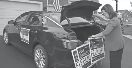  ?? JAY LAPRETE/AP ?? Jennifer Feucht, candidate for Olentangy Local Board of Education, delivers yard signs Thursday in Westervill­e, Ohio. After fighting to lift mask mandates and to get the district to declare its opposition to critical race theory, the mother of three says she has also been the victim of “vicious” attacks on social media.