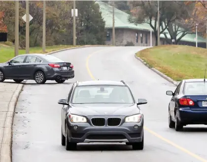  ?? JOHN MAHONEY ?? Cars drive on the section of Remembranc­e Rd. on Mount Royal that was closed from June 2 to Oct. 31 in a pilot project.