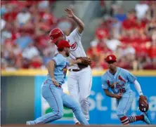  ??  ?? Cincinnati Reds’ Jesse winker (center) is out on a double play ball off the bat of Joey Votto as st. Louis Cardinals shortstop Paul DeJong (left) makes the tag during the first inning of a baseball game, on saturday in Cincinnati. AP Photo/GAry LAnderS