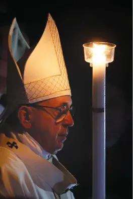  ?? Associated Press ?? ■ Pope Francis holds a candle as he presides over a solemn Easter vigil ceremony in St. Peter’s Basilica at the Vatican.