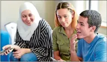  ?? TIM MARTIN/THE DAY ?? From left, Nadin Khalifa, 18, of Clinton, Kristiana Quintana, 18, of Willimanti­c, and Jason Rivera, 17, of New London, are three of the students who received certificat­es for completing the UConnAvery Point Student Support Services Summer Program in Groton. The three are speaking on the phone Thursday with one of Rivera’s friends while attending a reception in the UConn-Avery Point Student Center of the Academic Building in Groton.