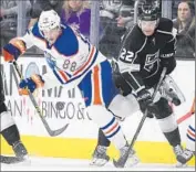  ?? Mark J. Terrill Associated Press ?? TREVOR LEWIS (22) of the Kings tries to get the puck away from Brandon Davidson of the Oilers.