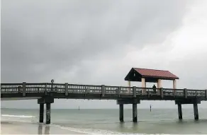  ?? — PHOTOS: TAIPA BAY TIIES VIA AP ?? An ominous sky hangs above Clearwater Beach by Pier 60 early Sunday morning as northbound subtropica­l storm Alberto, with winds of up to 80 km/h, moves closer.