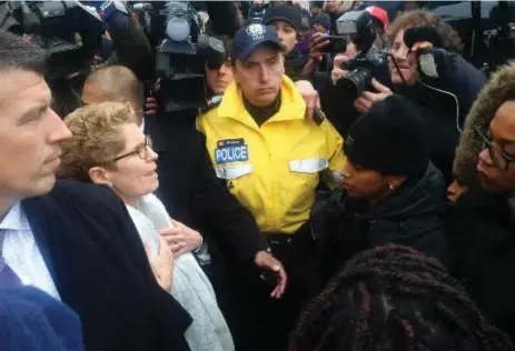  ?? ROBERT BENZIE/TORONTO STAR ?? Premier Kathleen Wynne, flanked by police officers, meets with Black Lives Matter protesters outside the Legislatur­e on Monday.