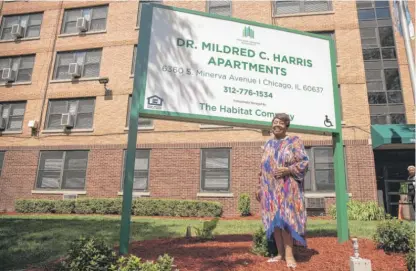  ?? PAT NABONG/SUN-TIMES PHOTOS ?? Chicago Housing Authority Commission­er Mildred Harris stands by a sign Wednesday at a newly rehabbed senior apartment building at 6360 S. Minerva Ave. in Woodlawn that will carry her name.