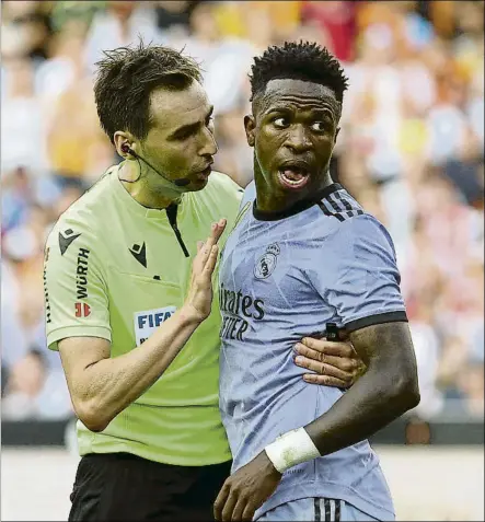  ?? FOTO: EFE ?? De Burgos Bengoetxea junto a Vinicius en el momento de más tensión vivido en Mestalla