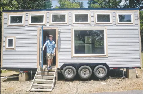  ?? (The Vicksburg Post/Courtland Wells) ?? Vicksburg, Miss., native David Osburn stands outside the 221-square-foot tiny house he designed and built as a teenager in Vicksburg. “I’ve always been somebody that likes to tinker with things, but I guess it really started when I saw a video on YouTube of a guy who converted a short bus into a tiny house. I said, ‘Hey, that’s pretty cool.’ Then I said I’ll sketch out my own design,” he said.