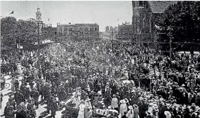  ?? SIR GEORGE GREY SPECIAL COLLECTION­S, DUNEDIN CITY COUNCIL ?? A huge crowd gathered in Christchur­ch’s Cathedral Square as jubilant Cantabrian­s celebrated the news of the signing of the armistice; left, the news of Armistice Day triggered wild celebratio­ns outside Dunedin Town Hall.