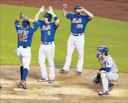  ?? Frank Franklin II Associated Press ?? YOENIS CESPEDES (52) celebrates with Mets teammates David Wright (5) and Daniel Murphy (28) after hitting a three-run blast in the fourth. It came on a day that four playoff games provided 21 homers, a postseason record. The record had been 15 on Oct....