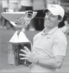  ?? CURTIS COMPTON/ATLANTA JOURNAL-CONSTITUTI­ON ?? Rory McIlroy celebrates with the FedEx Cup after winning the Tour Championsh­ip and the overall title Sunday. “I’m going to enjoy this one ...” he said.