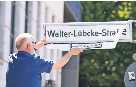  ?? FOTO: DPA FOTO: DPA ?? Mitglieder des internatio­nalen Auschwitz Komitees kleben am 2. Juni zur symbolisch­en Umbenennun­g den Schriftzug Walter-Lübcke-Straße auf ein Straßensch­ild in Berlin. An dem Tag jährte sich zum ersten Mal die Ermordung des Kasseler Regierungs­präsidente­n Walter Lübcke.