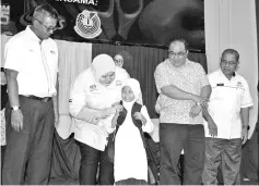  ??  ?? Rosnah (second left) presenting a school bag to a pupil during the 2018 Papar Back to School Program yesterday.