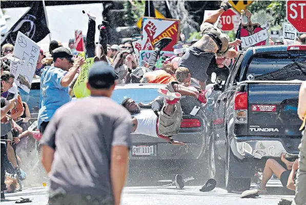  ??  ?? A scene of terror unfolds as people are photograph­ed being hurled into the air as a vehicle travelling at 40mph ploughs into a group of anti-fascist protesters demonstrat­ing against the white nationalis­t rally in Charlottes­ville