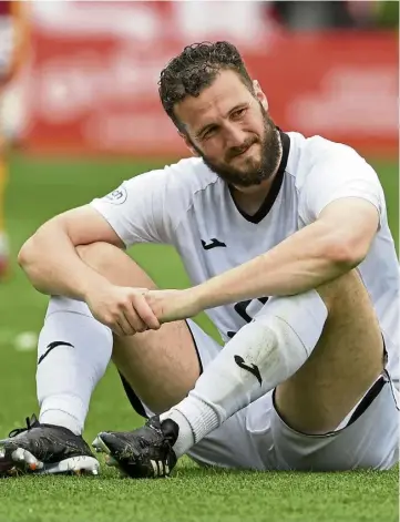  ?? ?? PAINFUL: Ross County’s Alex Iacovitti looks dejected after Kevin van Veen’s late record-breaking penalty, left, gave Motherwell a 1-0 victory at Fir Park on Saturday.