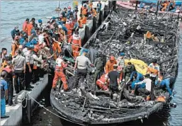  ?? RHANA ANANDA/AP ?? Rescuers search for victims after a ferry caught fire off the coast of Jakarta on Sunday.