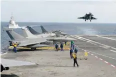  ?? — AFP ?? A French Rafale fighter jet lands on the “Charles de Gaulle” aircraft carrier in the Mediterran­ean sea.