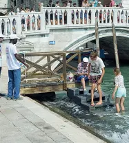  ??  ?? Decoro Turisti con i piedi a bagno e un Guardians che cerca di spiegargli che è vietato (Vision)