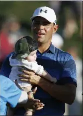  ?? ROSS D. FRANKLIN —ASSOCIATED PRESS ?? Gary Woodland holds his son Jaxson on the 18th green after winning the Phoenix Open Feb. 4.