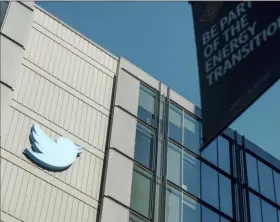  ?? Associated Press ?? A Twitter logo hangs outside the company's San Francisco offices. Twitter boss Elon Musk said on Friday that he suspended the account of Kanye West, who now goes by Ye, after the rapper shared an image of a swastika combined with the Star of David.