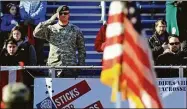  ?? Christian Abraham / Hearst Connecticu­t Media ?? US Army Captain Christophe­r Couch salutes the flag during the 8th Annual Sticks for Soldiers 2013 Thanksgivi­ng Lacrosse Classic at Ludlowe High School’s Taft Field.