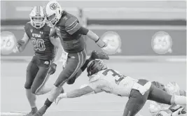  ?? ETHAN MILLER/GETTY ?? Utah quarterbac­k Cameron Rising (7) oavoids a tackle by Oregon’s Jordan Happle in the Pac-12 championsh­ip game Friday at Allegiant Stadium in Las Vegas, Nevada.