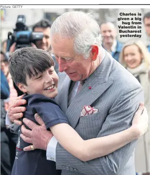  ?? Picture: GETTY ?? Charles is given a big hug from Valentin in Bucharest yesterday