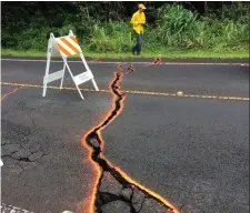  ??  ?? Scientists measure cracks in the road in Hawaii. Photo: Reuters