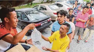  ??  ?? Orang ramai beratur mengambil air yang diberi pihak SYABAS ketika tinjauan masalah air yang dihadapi penduduk USJ 1 hingga USJ 16, semalam. (Gambar kanan) seorang warga emas terpaksa mengangkat air yang diambil daripada lori tangki air SYABAS...