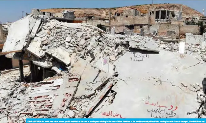  ??  ?? KHAN SHAYKHUN: An aerial view taken shows graffiti scribbled on the roof of a collapsed building in the town of Khan Sheikhun in the southern countrysid­e of Idlib, reading in Arabic ‘truce is betrayal’, ‘Russia kills us and the civil defense saves us’, and other insults against Russian President Vladimir Putin. — AFP