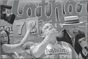  ?? Bebeto Matthews / The Associated Press ?? Joey Chestnut eats two hot dogs at a time during the Nathan’s Annual Famous Internatio­nal Hot Dog Eating Contest on Tuesday in New York.