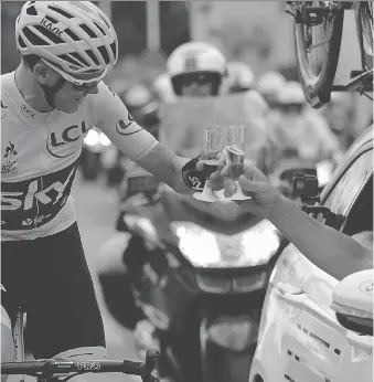  ?? BENOIT TESSIER/GETTY IMAGES ?? Chris Froome, wearing the overall leader’s yellow jersey, toasts with champagne as he takes the start of the 103-kilometre final stage of the Tour de France in Montgeron, France, on Sunday. The 32-year-old won his fourth Tour de France title when the...