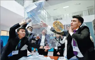  ?? VYACHESLAV OSELEDKO / AFP ?? Electoral commission workers empty a ballot box at a polling station in Astana after Kazakhstan’s presidenti­al elections on Sunday.