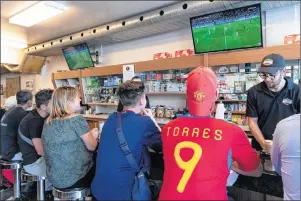  ?? CP PHOTO ?? Patrons in an Italian cafe watch Portugal play Spain in the World Cup on Friday.