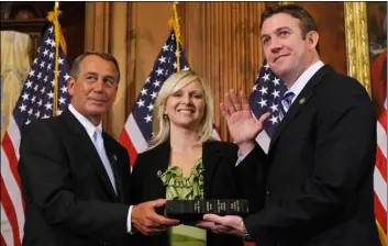  ?? AP Photo/Alex BrAndon ?? In this 2011, file photo, House Speaker John Boehner of Ohio (left) administer­s the House oath to Rep. Duncan Hunter, R-Calif., as his wife, Margaret, looks on during a mock swearing-in ceremony on Capitol Hill in Washington.