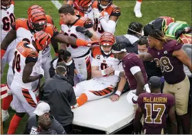  ?? AL DRAGO — THE ASSOCIATED PRESS ?? Cincinnati Bengals quarterbac­k Joe Burrow (9) shakes hands with Washington Football Team quarterbac­k Dwayne Haskins (7) as Burrows is carted away off the field during the second half of an NFL football game, Sunday, Nov. 22, 2020, in Landover. Burrows left the game with a left knee injury.