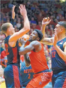  ?? ADOLPHE PIERRE-LOUIS/JOURNAL ?? UNM’s Corey Manigault, center, is surrounded by San Diego State defenders Malachi Flynn, left, Adam Seiko (2) and Nolan Norain, right, during Wednesday night’s game.