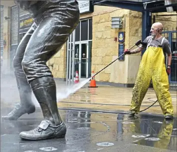  ?? Lucy Schaly/Post-Gazette ?? SPRING CLEANING Aramark employee Dean Ostella power washes the Willie Stargell statue Wednesday outside the left-field gate of PNC Park on Federal Street. It’s the first chance Ostella has had to do this work since returning from a 79-day layoff as non-essential businesses were shut down because of the COVID-19 pandemic.