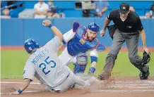  ?? NATHAN DENETTE/ THE CANADIAN PRESS ?? Jays catcher Russell Martin misses the tag at home plate on the Royals’ Kendrys Morales on Friday.