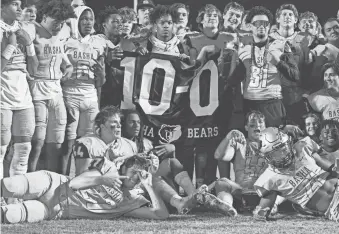  ?? ALEX GOULD/SPECIAL TO THE REPUBLIC ?? Basha football poses for a photo while holding a 10-0 flag at Jim Wall Stadium in Chandler. After defeating Mountain View, Basha finished ended its regular season undefeated in the 6A Central.