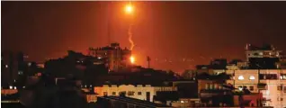  ?? - AFP ?? AIR STRIKES: A picture shows flares dropped by Israeli warplanes above Gaza city. Israel’s military said it was carrying out air strikes “throughout the Gaza Strip” after a barrage of rocket fire from the Palestinia­n enclave towards its territory.