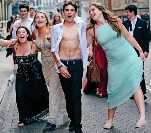  ??  ?? Having a ball: Students stumble through the streets of Cambridge having partied all night at Trinity May Ball