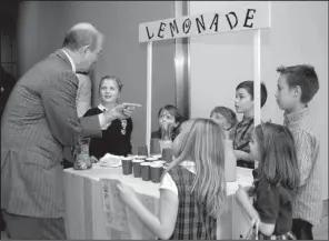  ?? Arkansas Democrat- Gazette/ JEFF MITCHELL ?? Rotarian Kenny Gibbs ( left) talks to the children of other Rotarians about the book The Lemonade War as the children sell lemonade at the Clinton Presidenti­al Center in Little Rock on Tuesday.