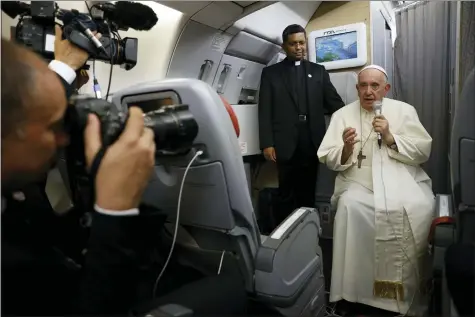  ?? PHOTOS BY GUGLIELMO MANGIAPANE — POOL VIA AP ?? Pope Francis speaks to journalist­s July 30aboard the papal flight back from Canada, where he paid a six-day pastoral visit. Pope Francis wrapped up his Canadian pilgrimage by meeting with Indigenous delegation­s and visiting Inuit territory in northern Nunavut. In one of his addresses, he assailed the Catholic missionari­es who “supported oppressive and unjust policies” against Native peoples in the country’s notorious residentia­l schools and vowed to pursue truth and healing.