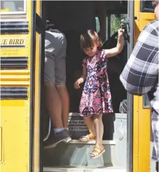  ??  ?? Livi Langston rode the bus without her mom, and did great — rememberin­g to watch her step on the way down.