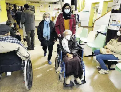  ?? JAIME GALINDO ?? Carmen, en la silla de ruedas, su hija Pepa, con bufanza azul, y su bisnieta, ayer yendo a vacunarse en Zaragoza.