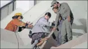  ?? AP ?? Volunteers help a foreigner escape after a fire that broke out at a hotel in Karachi on Monday.