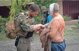  ?? EFREM LUKATSKY/AP ?? A paramedic helps a man wounded by the Russian shelling at the man’s house in Slovyansk, Donetsk region, Ukraine, on Thursday.
