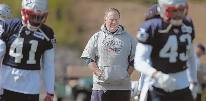  ?? STAFF PHOTO BY NANCY LANE ?? STERN FOCUS: Patriots coach Bill Belichick keeps an eye on things during practice yesterday in Foxboro.
