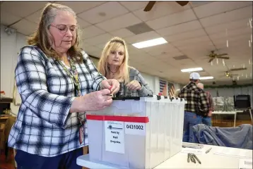  ?? FRED GREAVES — CALMATTERS ?? Poll workers Twyla Carpenter, left, and Regina Jasperse inspect the lock on a mail ballot drop box at a polling station at the American Legion in Shasta County on Nov. 7.