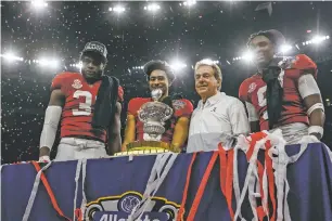  ?? BUTCH DILL/THE ASSOCIATED PRESS ?? From left, linebacker Will Anderson Jr., quarterbac­k Bryce Young, head coach Nick Saban and defensive back Jordan Battle stand with the Sugar Bowl trophy Saturday in New Orleans. Anderson, Young and Battle all opted to play in the game despite being projected as high NFL picks.